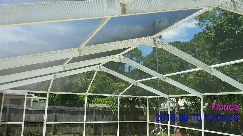 Pressure washing beore picture of pool cage